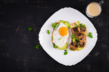 Sandwiches  with avocado, fried egg and mushrooms  for healthy breakfast or snack. Top view, above