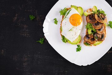 Sandwiches  with avocado, fried egg and mushrooms  for healthy breakfast or snack. Top view, above