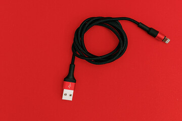 Black usb cord on red background, subject technology