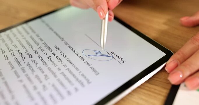 Hand of businesswoman partner holds stylus and puts electronic signature in contract on tablet