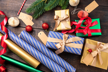 Festive christmas new year background colorful gift boxes and holiday decorations on wood background. New Year's present and Christmas gift box top view