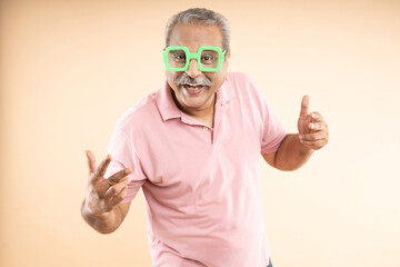 Cheerful crazy senior old man wearing funky eyeglasses and doing doing thumbs up with both his hands and shouting , Retirement life, Success in business, © GAJENDRRA BHATI 