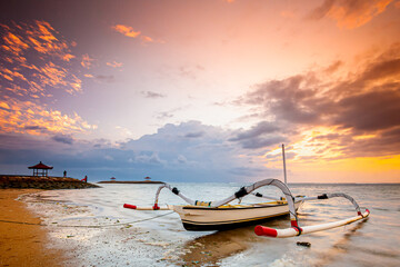 Traditional Balinese ships Jukung in Sanur beach at sunrise, Bali, Indonesia