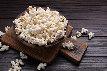 Tasty popcorn on black wooden table, closeup