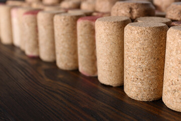 Many corks of wine bottles on wooden table, closeup