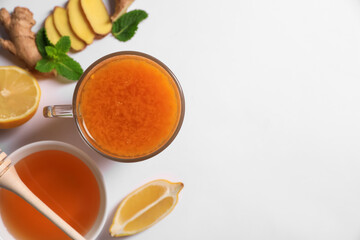 Delicious ginger tea and ingredients on white background, flat lay. Space for text