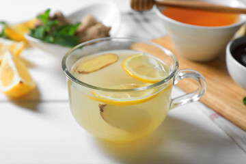 Delicious ginger tea and ingredients on white wooden table
