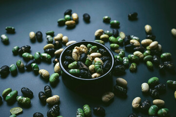 Elegant flat lay in dark tones of three color roasted edamame