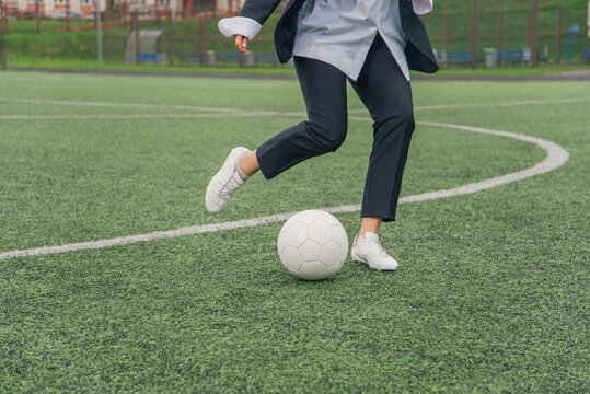 Girl soccer player office manager kicks soccer ball.