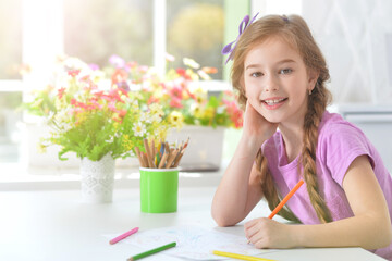 Cute little preschooler child drawing at home