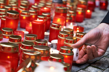 Hand lighting a candle at Velvet Revolution anniversary in Prague, Czech Republic