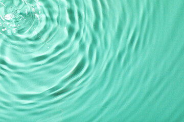 Closeup view of water with rippled surface on light blue background