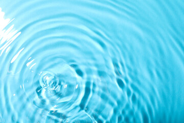 Naklejka na ściany i meble Closeup view of water with rippled surface on light blue background