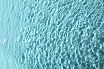 Closeup view of water with rippled surface on light blue background