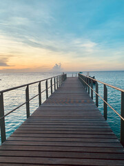 Obraz premium Wooden pier at sunset. Seascape with sunset lights.