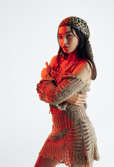 Young woman poses against white background with red backlight.