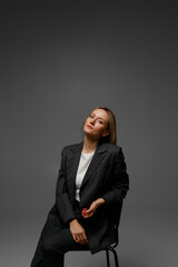 middle aged woman in office suit in studio with gray background