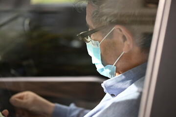 A masked taxi driver waiting in his car for guests in Valencia-Spain.