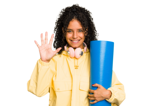 Young sport brazilian woman holding a matt isolated smiling cheerful showing number five with fingers.