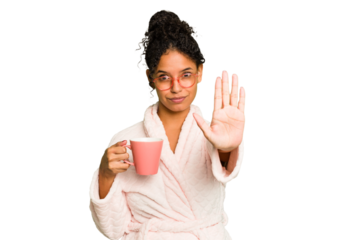 Young brazilian woman wearing a pajama holding a cup isolated standing with outstretched hand showing stop sign, preventing you.