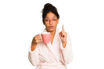 Young brazilian woman wearing a pajama holding a cup isolated having some great idea, concept of creativity.