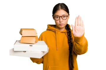Young student asian woman holding a takeaway food isolated standing with outstretched hand showing stop sign, preventing you.