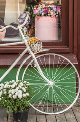 Fototapeta na wymiar Decorative bicycle, painted white at the entrance to the cafe.