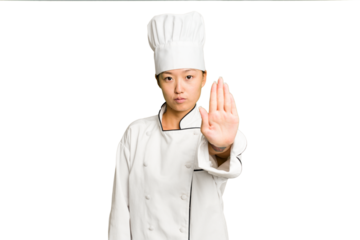 Young asian cook woman isolated standing with outstretched hand showing stop sign, preventing you.