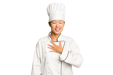 Young asian cook woman isolated laughs out loudly keeping hand on chest.