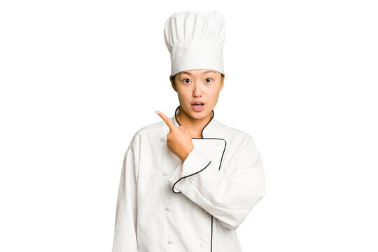 Young asian cook woman isolated pointing to the side