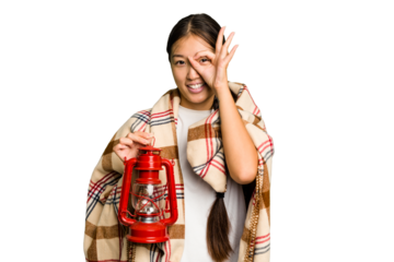 Young asian woman wearing a blanket and holding a lamp isolated excited keeping ok gesture on eye.