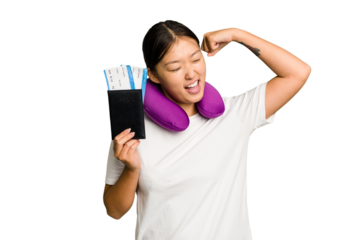Young asian woman with inflatable travel pillow on her neck holding passport isolated raising fist after a victory, winner concept.