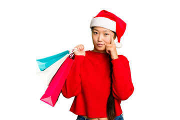 Young asian woman shopping a christmas presents isolated Young asian woman shopping a christmas presents isolated pointing temple with finger, thinking, focused on a task.