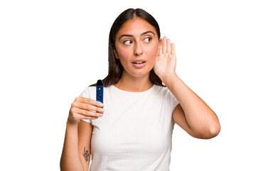 Young caucasian woman holding a electronic cigarette trying to listening a gossip.