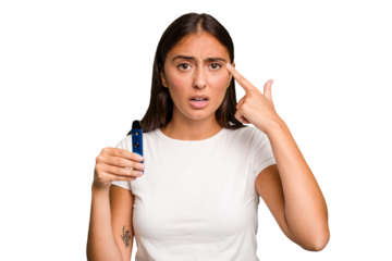 Young caucasian woman holding a electronic cigarette showing a disappointment gesture with forefinger.