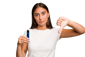 Young caucasian woman holding a electronic cigarette showing a dislike gesture, thumbs down. Disagreement concept.