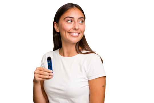 Young caucasian woman holding a electronic cigarette looks aside smiling, cheerful and pleasant.