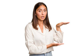 Young cute caucasian woman isolated shocked and amazed holding a copy space between hands.