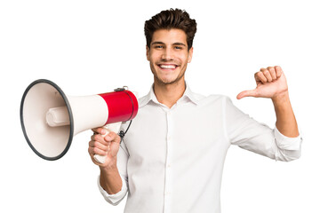 Young caucasian man holding megaphone isolated person pointing by hand to a shirt copy space, proud and confident