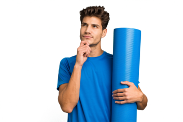Young caucasian sport man holding a mat isolated looking sideways with doubtful and skeptical expression.