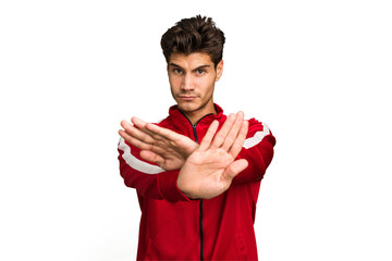 Young caucasian handsome man isolated standing with outstretched hand showing stop sign, preventing...
