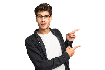 Young caucasian handsome man isolated shocked pointing with index fingers to a copy space.