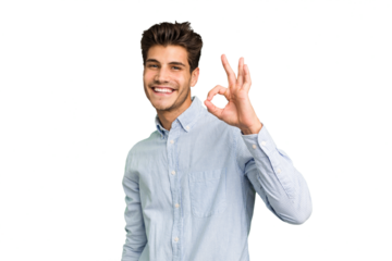 Young caucasian handsome man isolated winks an eye and holds an okay gesture with hand.
