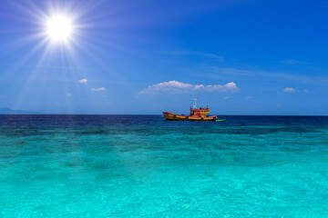 Obraz premium Orange ferry ship in azure sea, Loh Moo Dee Beach, Phi Phi Don,