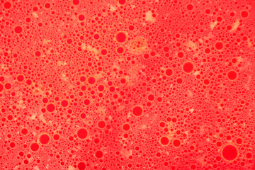 Abstract red background with round spots of various shapes.