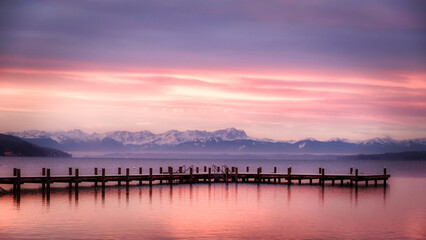 Fototapeta na wymiar Starnberger See im Winter mit Steg und Alpen bei Sonnenaufgang