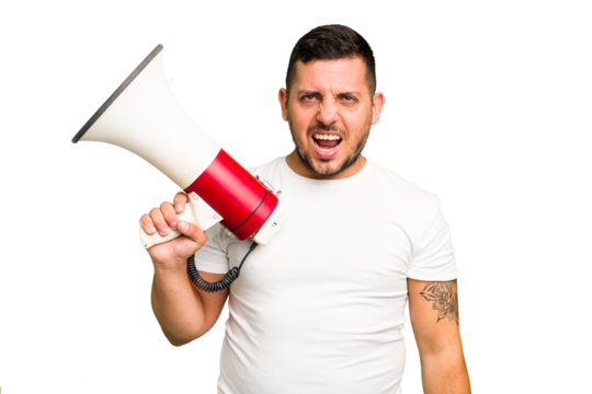 Young caucasian man holding a megaphone isolated screaming very angry and aggressive.