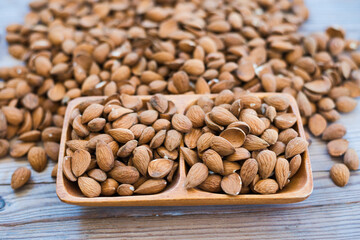 Almonds nuts on wooden bowl on table background , top view  almond
