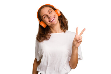 Young caucasian woman listening to music with headphones isolated joyful and carefree showing a...