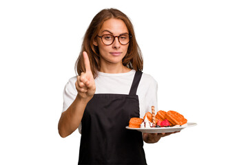 Young caucasian woman holding a waffles dish isolated showing number one with finger.